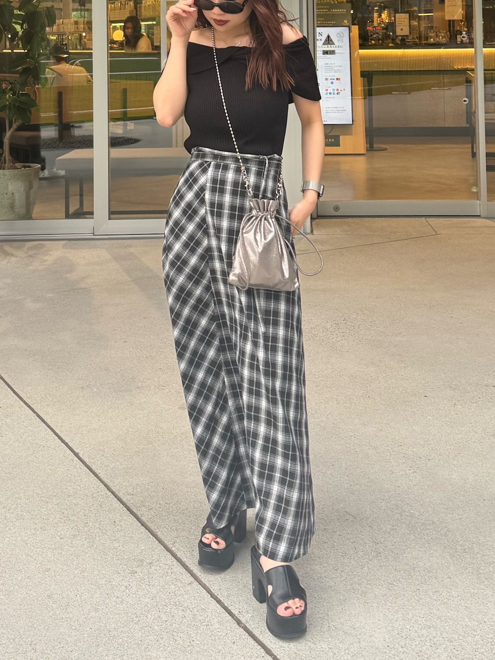 ブラック系のスカート、ブラック系のニット/セーター、ブラック系のサンダルを着用したレディースの夏コーディネートの5枚目の写真