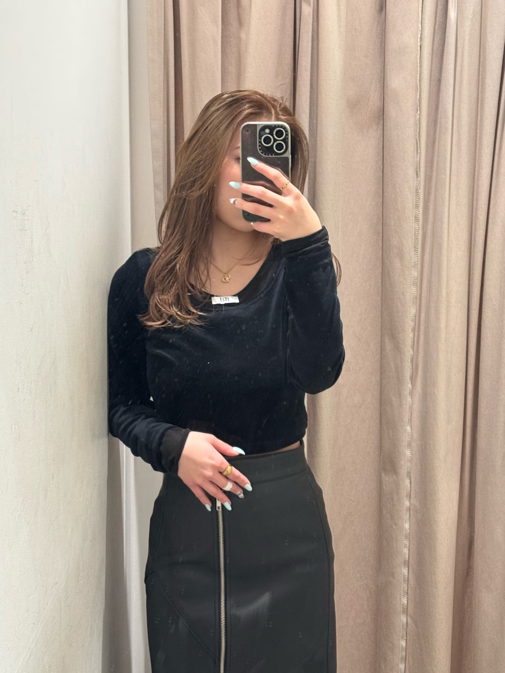 ブラック系のスカート、ブラック系のTシャツ/カットソー、ブラック系のブーツを着用したレディースの冬コーディネートの4枚目の写真