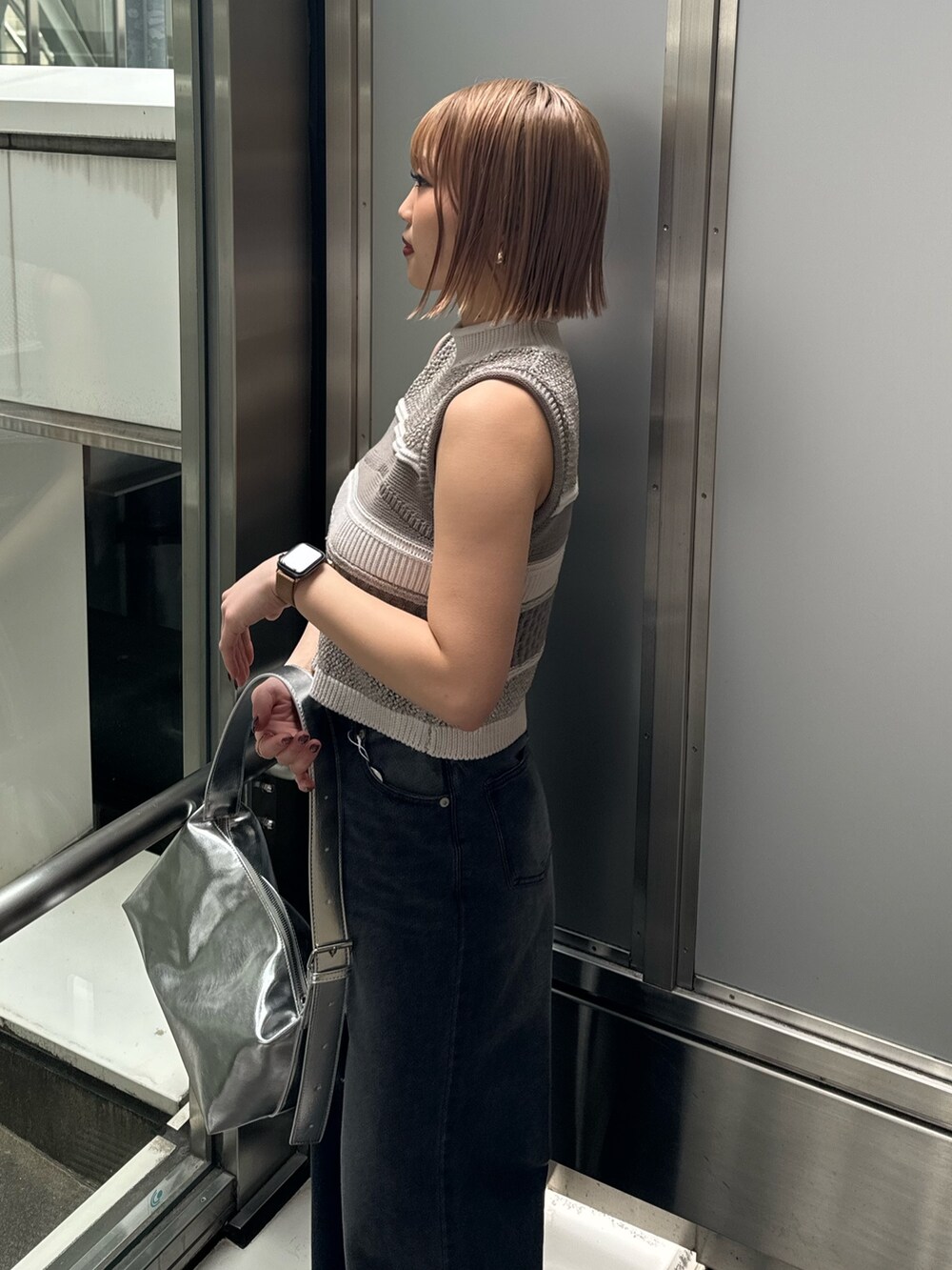 グレー系のニット/セーター、ブラック系のデニムパンツを着用したレディースの春コーディネートの8枚目の写真