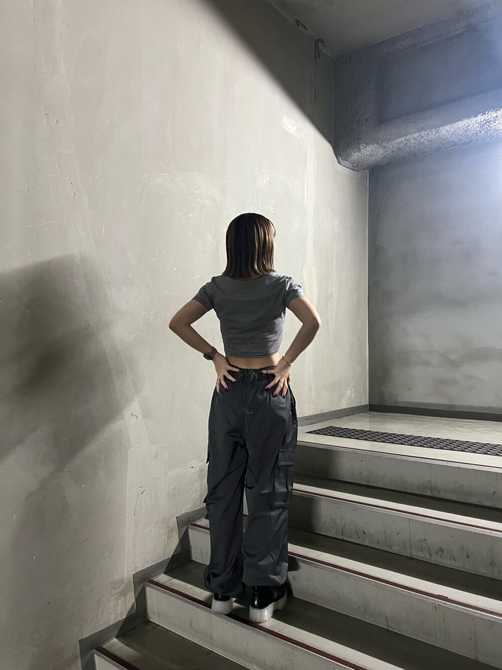 グレー系のカーゴパンツ、その他のTシャツ/カットソー、ブラック系のブーツを着用したレディースの秋コーディネートの5枚目の写真