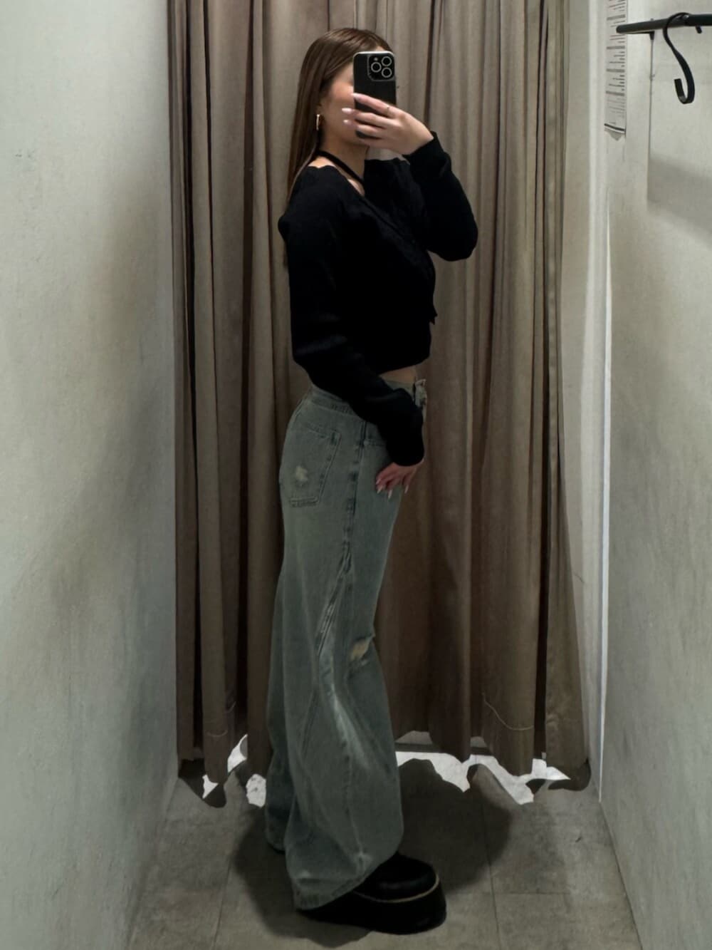 ブラック系のブーツ、ブルー系のデニムパンツ、ブラック系のニット/セーターを着用したレディースの春コーディネートの2枚目の写真