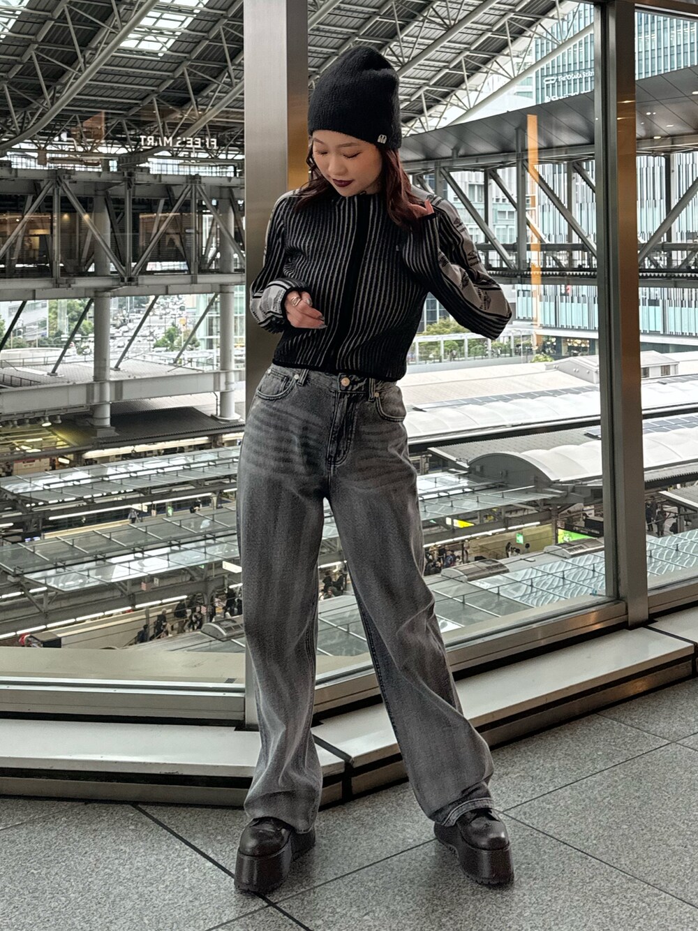 ブラック系のニット/セーター、ブラック系のデニムパンツ、ブラウン系のブーツを着用したレディースの秋コーディネートの4枚目の写真