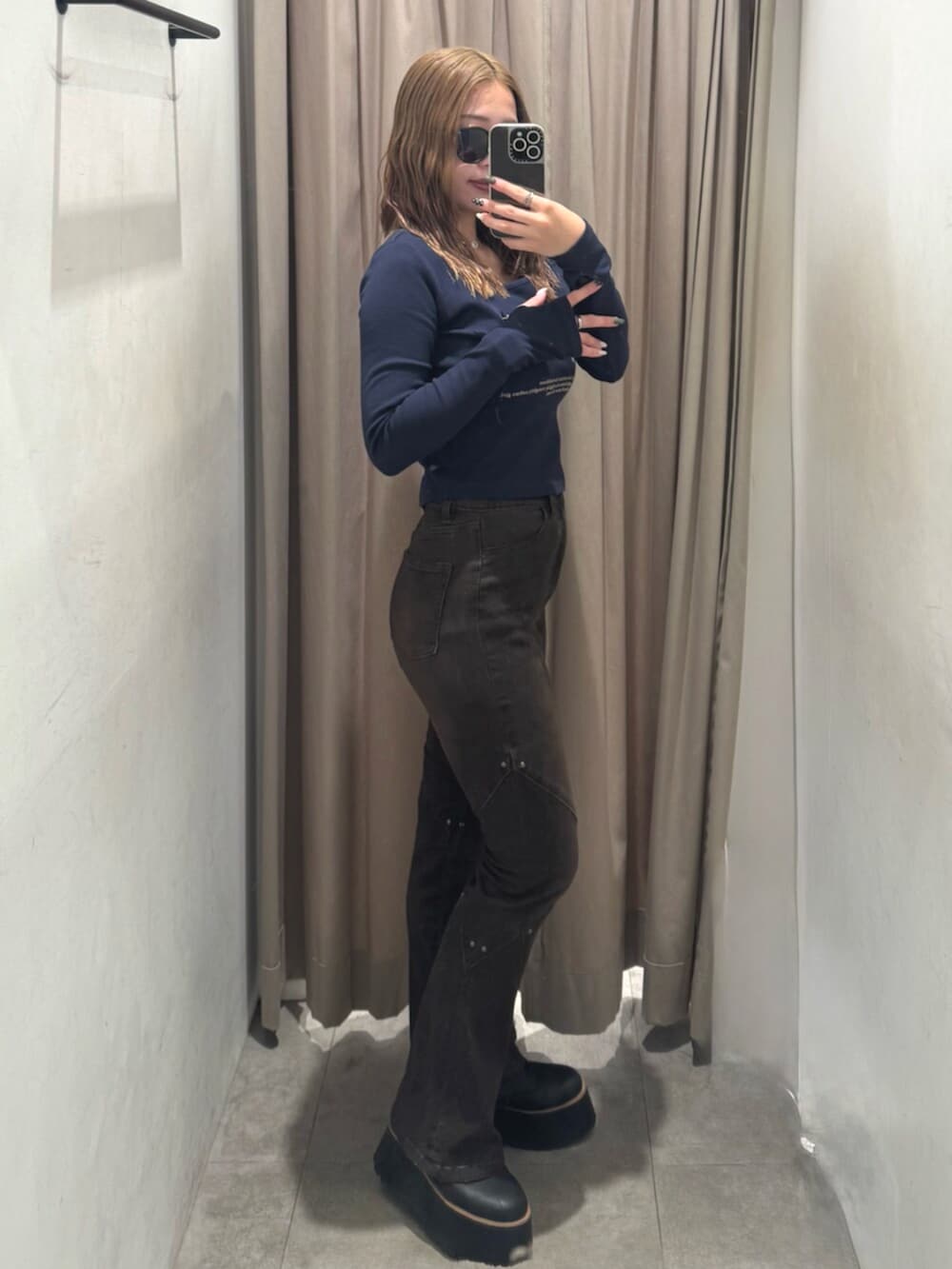 ブラック系のブーツ、ブラウン系のデニムパンツ、ブルー系のTシャツ/カットソーを着用したレディースの秋コーディネートの2枚目の写真