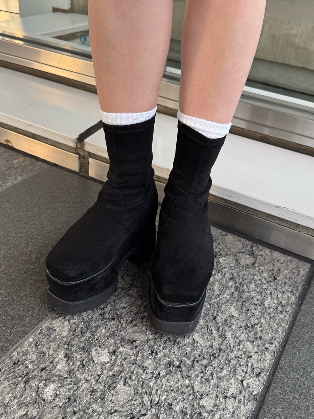 ブラウン系のブルゾン、ブラック系のスカート、ブラック系のブーツを着用したレディースの冬コーディネートの7枚目の写真