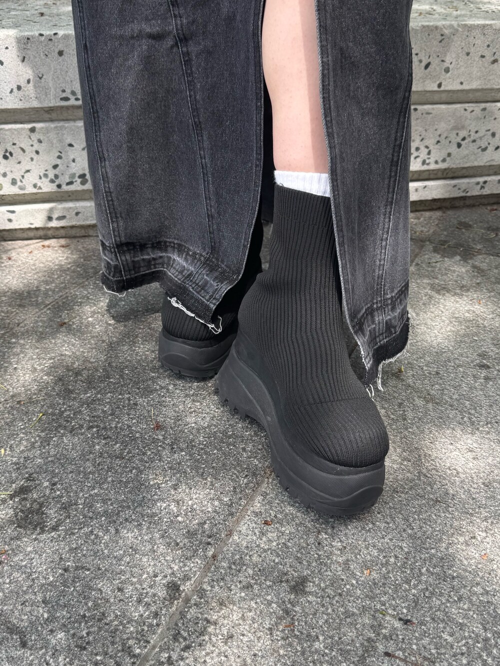 レッド系のTシャツ/カットソー、ブラック系のデニムスカート、ブラック系のブーツを着用したレディースの春コーディネートの7枚目の写真