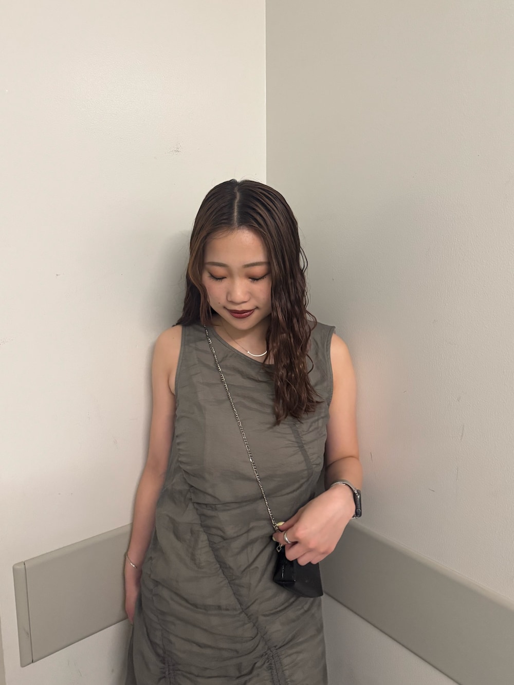 グレー系のワンピース、ブルー系のデニムパンツ、ブラック系のサンダルを着用したレディースの夏コーディネートの5枚目の写真