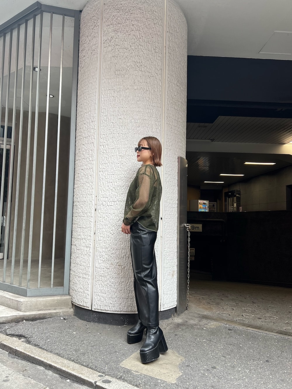 グリーン系のTシャツ/カットソー、ブラック系のスカートを着用したレディースの冬コーディネートの2枚目の写真