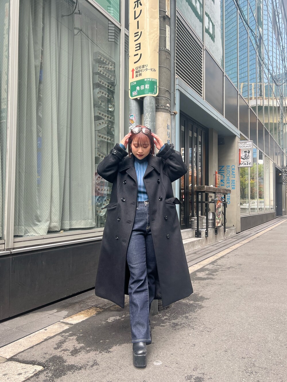 ブラック系のチェスターコートを着用したレディースの秋コーディネートの7枚目の写真