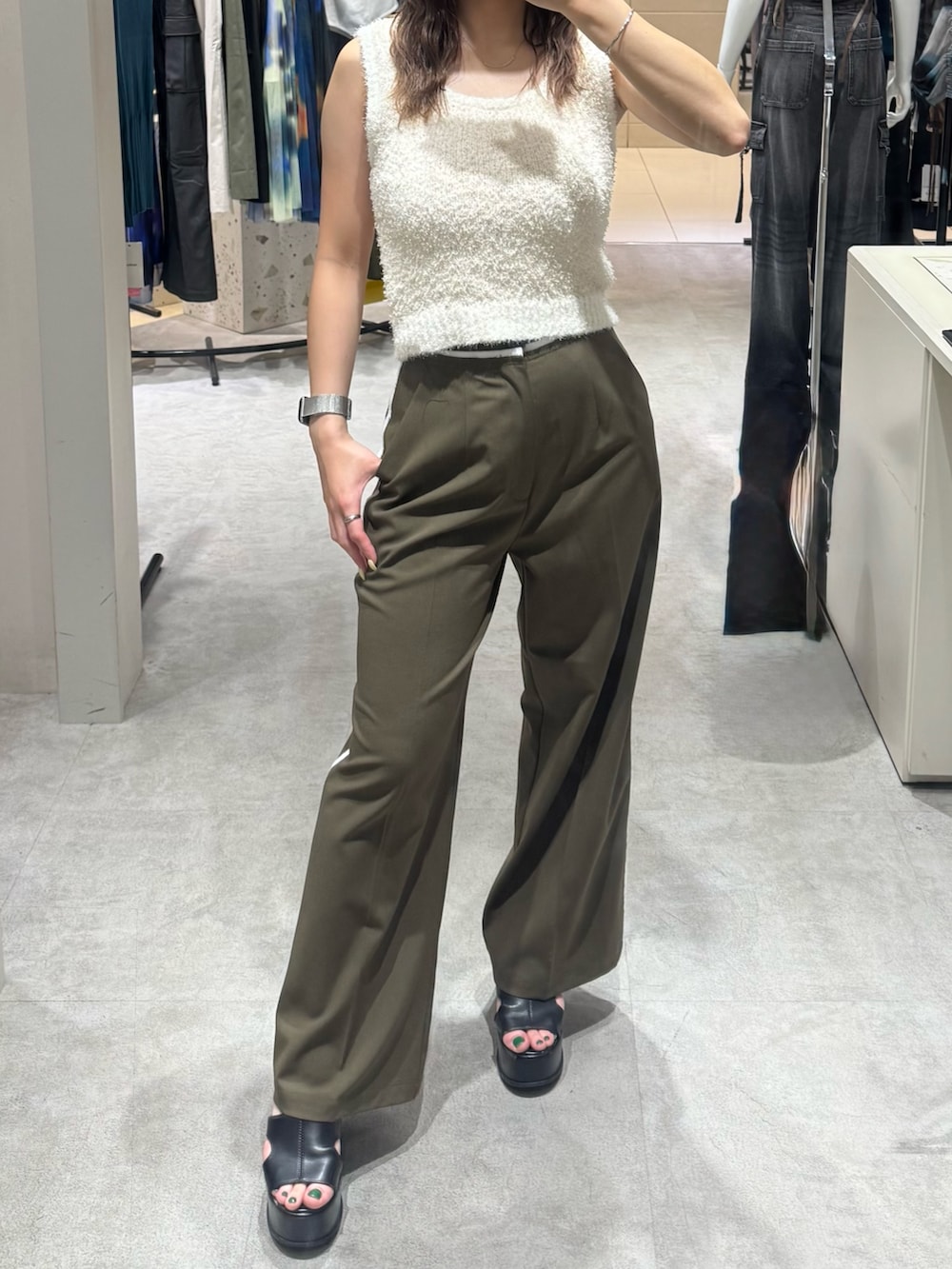 ホワイト系のニット/セーター、グリーン系のその他パンツ、ブラック系のサンダルを着用したレディースの夏コーディネートの5枚目の写真