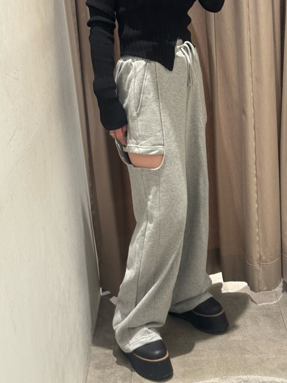 グレー系のスウェットパンツ、ブラック系のニット/セーター、ブラック系のブーツを着用したレディースの秋コーディネートの5枚目の写真