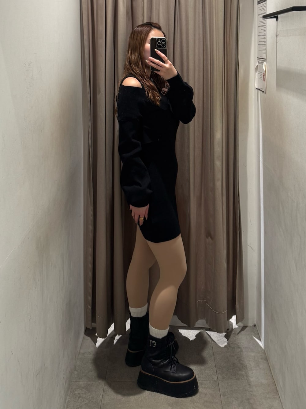 ブラック系のワンピース、ブラック系のブーツを着用したレディースの冬コーディネートの2枚目の写真