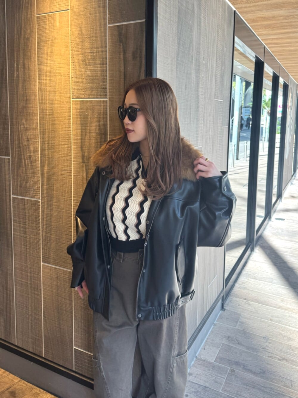 ブラック系のブーツ、ブラック系のブルゾン、ブラウン系のその他パンツを着用したレディースの冬コーディネートの4枚目の写真