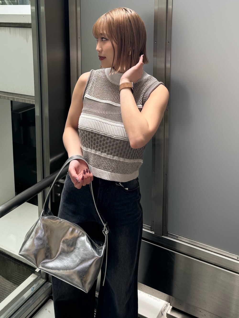 グレー系のニット/セーター、ブラック系のデニムパンツを着用したレディースの春コーディネートの7枚目の写真