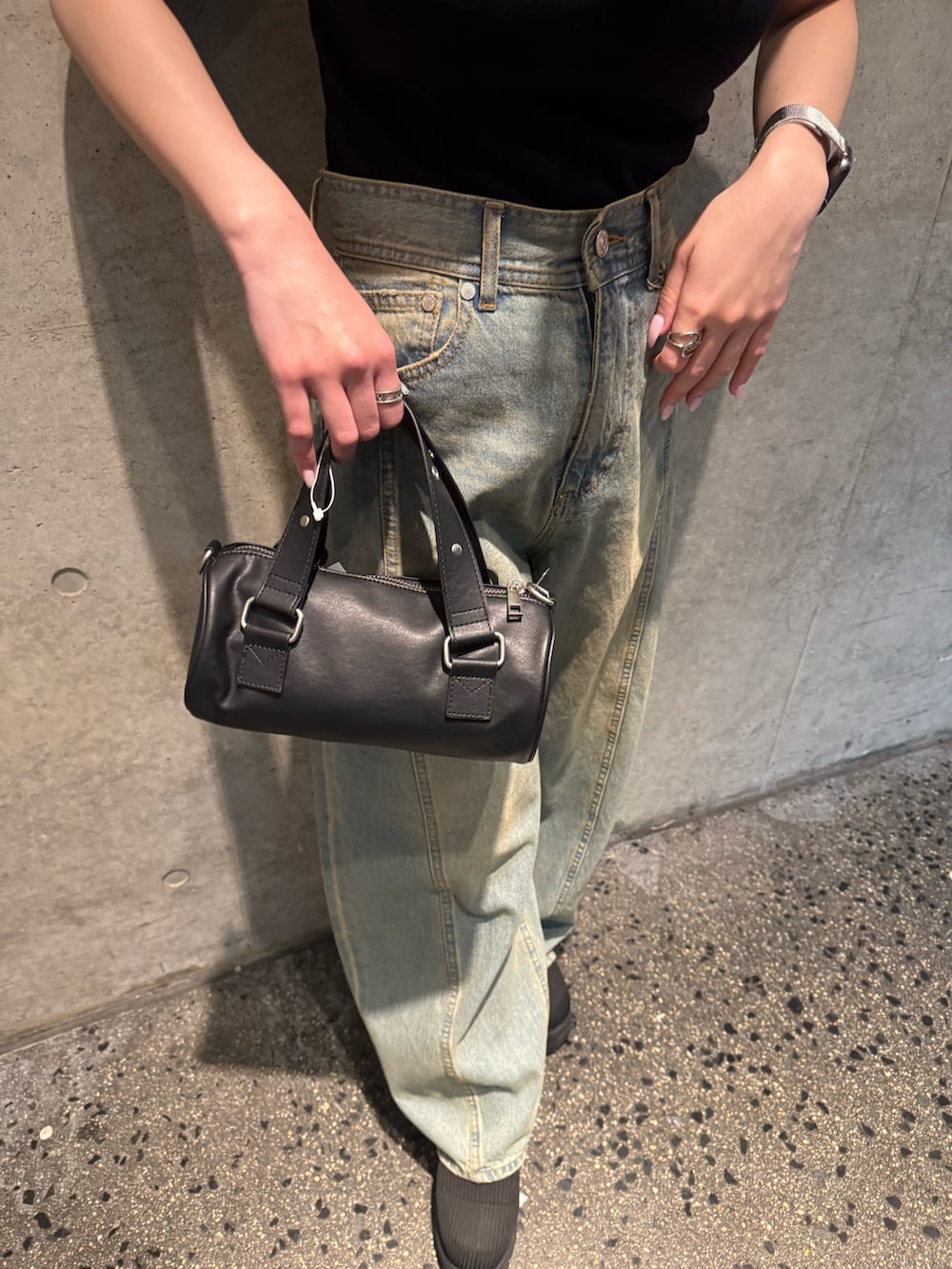 ブラック系のTシャツ/カットソー、ブルー系のデニムパンツ、ブラック系のブーツを着用したレディースの春コーディネートの7枚目の写真