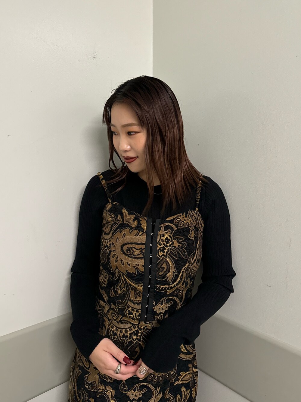 ブラック系のキャミソール、ブラック系のスカート、ブラウン系のブーツを着用したレディースの秋コーディネートの4枚目の写真