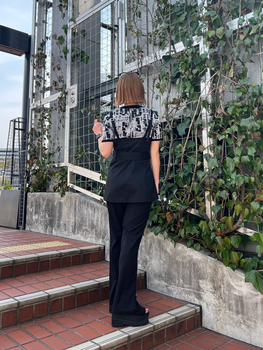 ブラック系のニット/セーター、ブラック系のシャツ/ブラウス、ブラック系のその他パンツを着用したレディースの春コーディネートの3枚目の写真