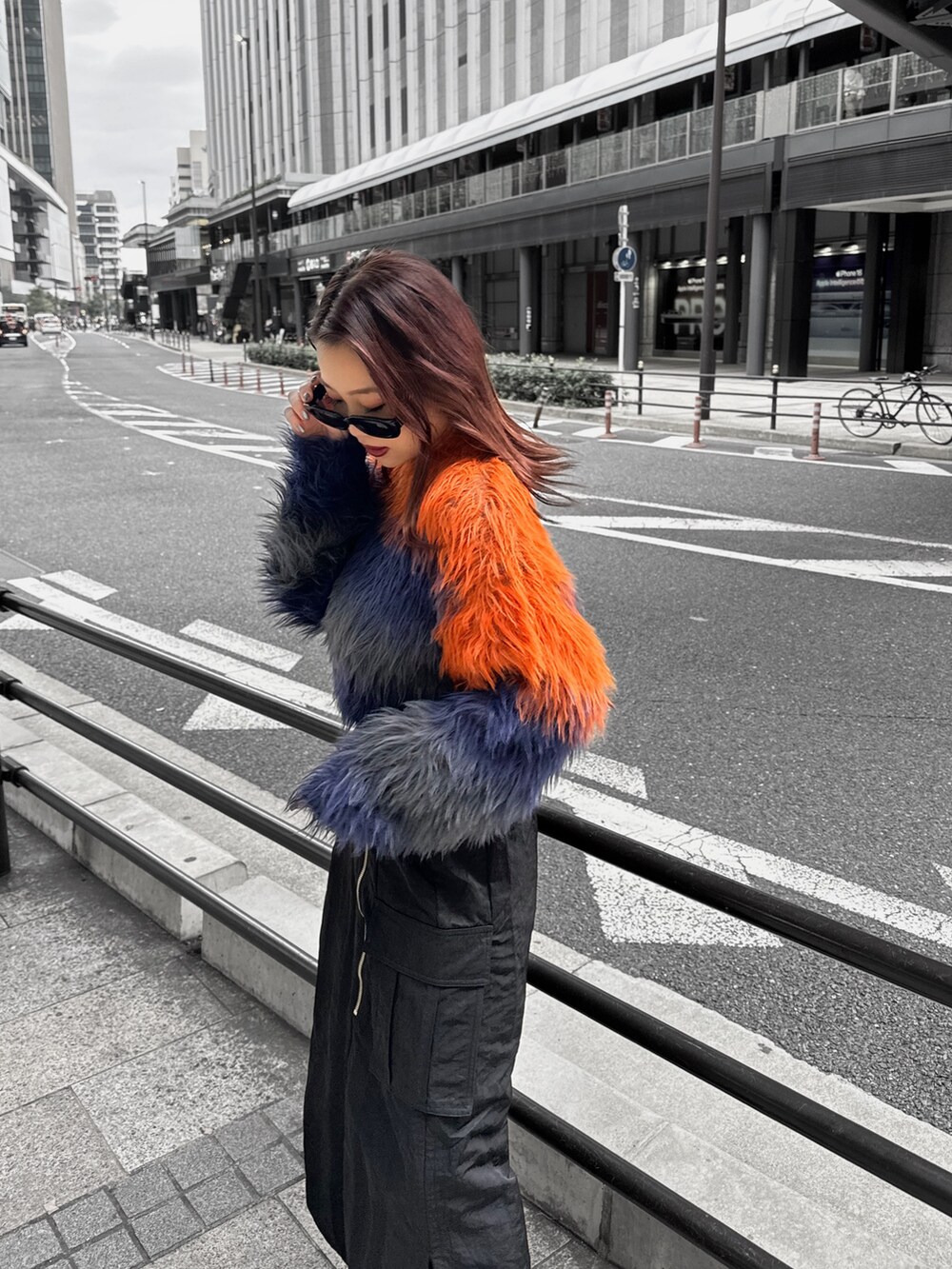 オレンジ系のニット/セーター、ブラック系のスカート、ブラウン系のブーツを着用したレディースの秋コーディネートの6枚目の写真