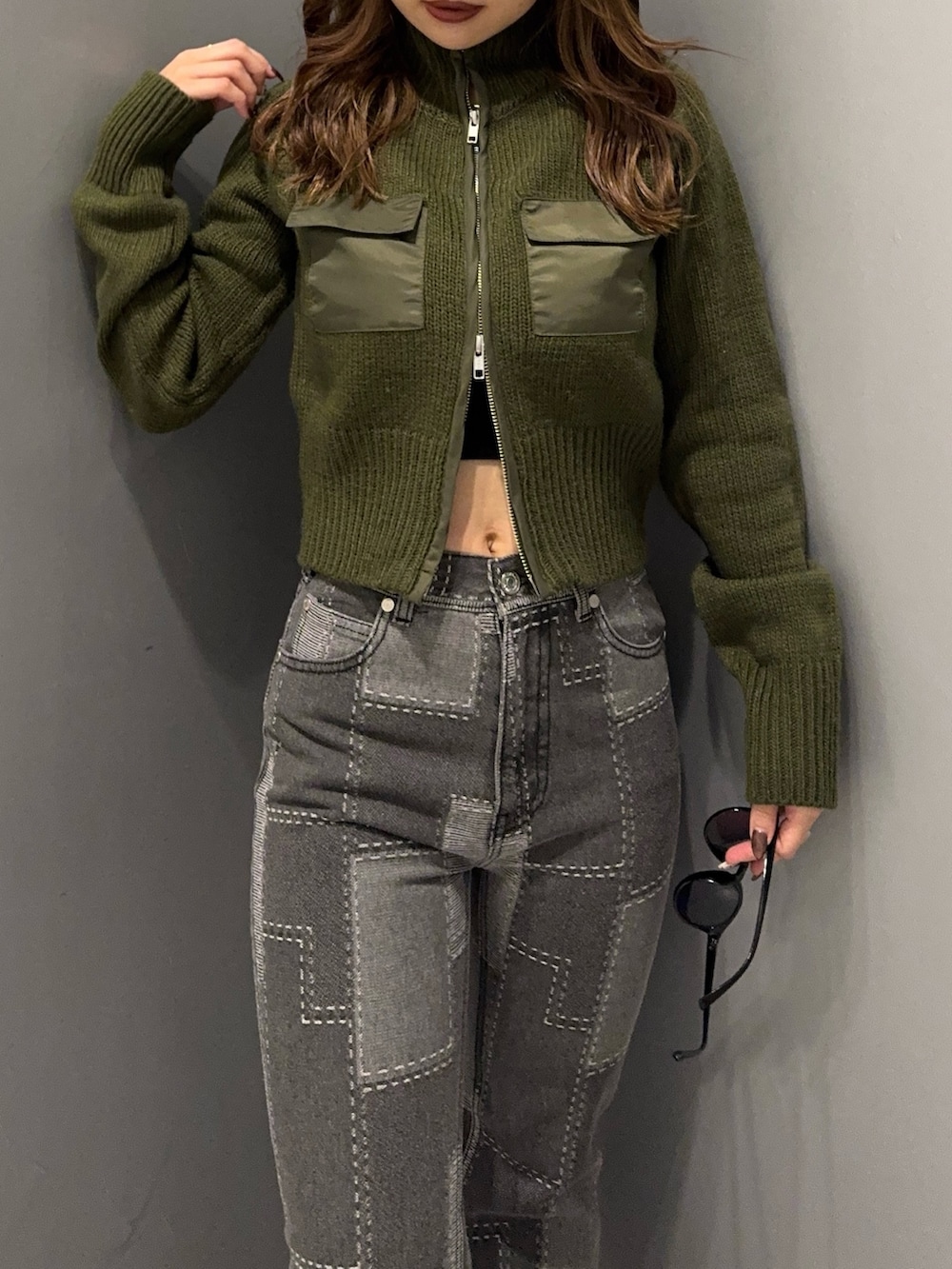 ブラック系のデニムパンツ、グリーン系のニット/セーター、ブラック系のブーツを着用したレディースの秋コーディネートの4枚目の写真