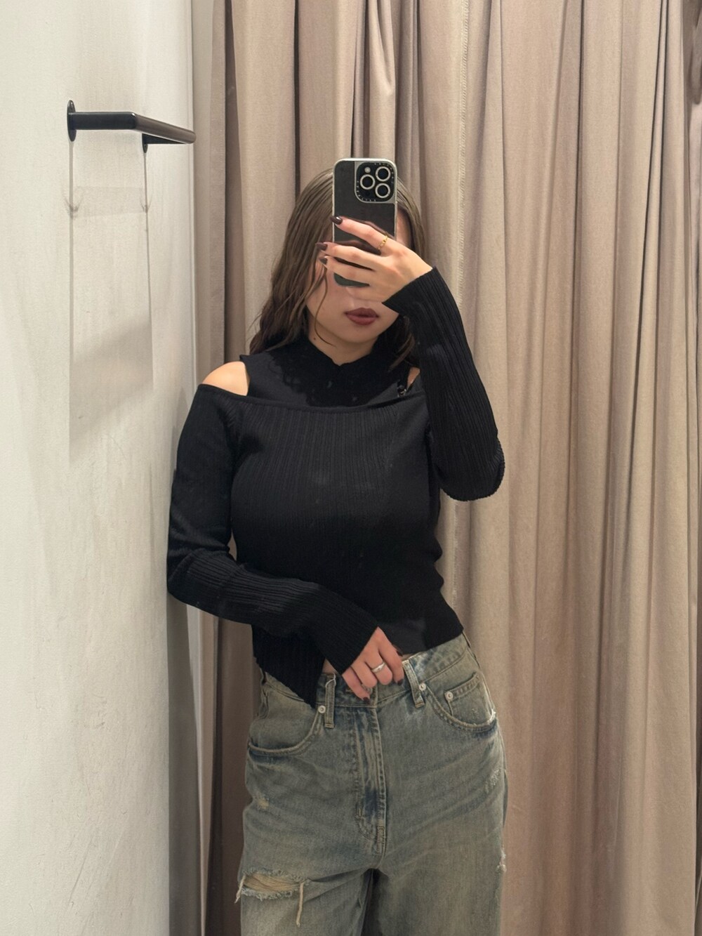 ブルー系のデニムパンツ、ブラック系のニット/セーター、ブラック系のブーツを着用したレディースの秋コーディネートの5枚目の写真