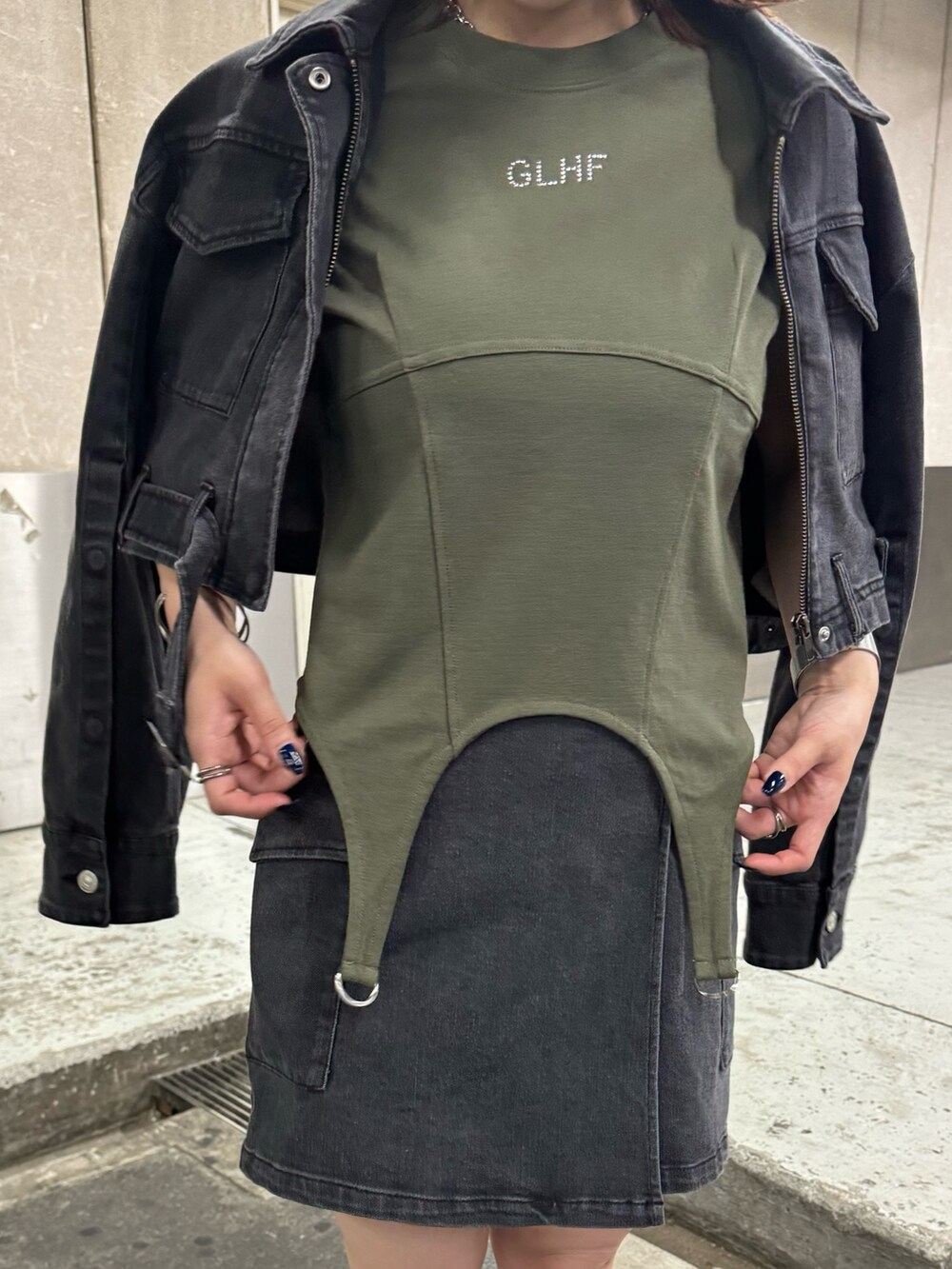 ブラック系のデニムジャケット、ブラック系のスカート、グリーン系のTシャツ/カットソーを着用したレディースの夏コーディネートの10枚目の写真