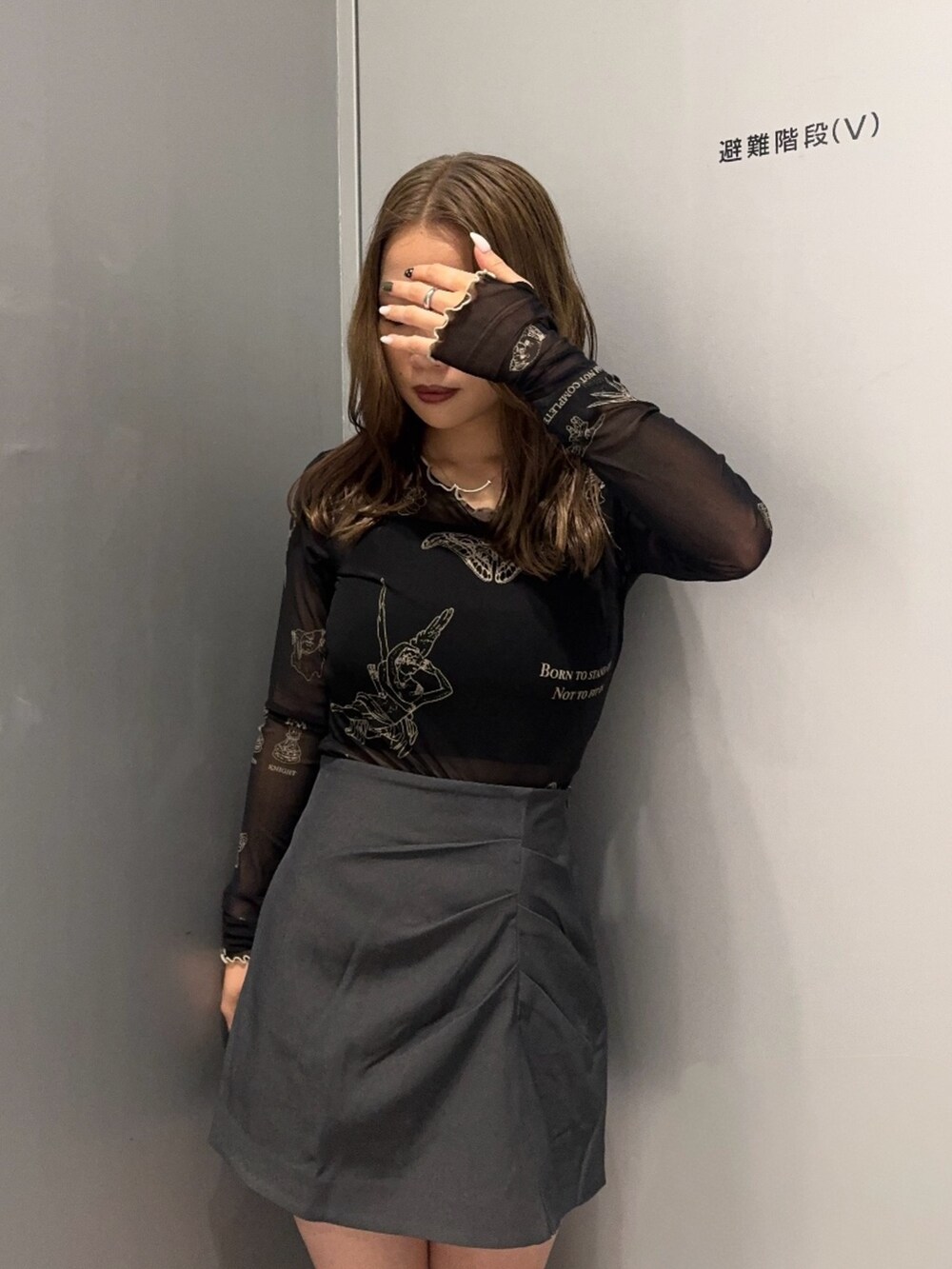 ブラック系のTシャツ/カットソー、グレー系のスカート、ブラック系のブーツを着用したレディースの秋コーディネートの4枚目の写真