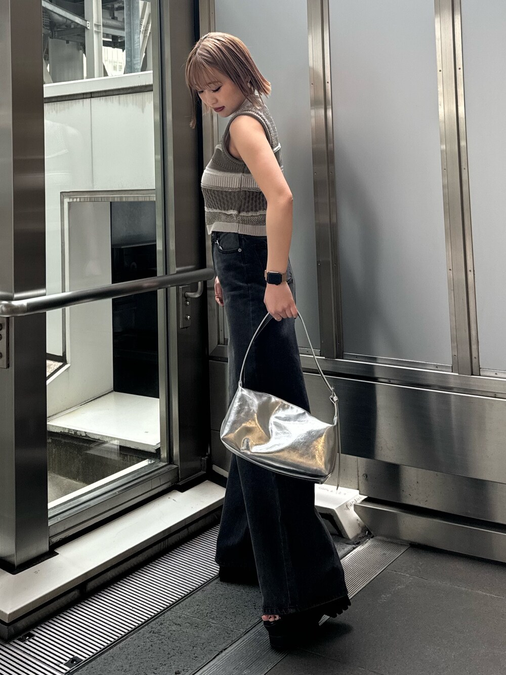 グレー系のニット/セーター、ブラック系のデニムパンツを着用したレディースの春コーディネートの5枚目の写真