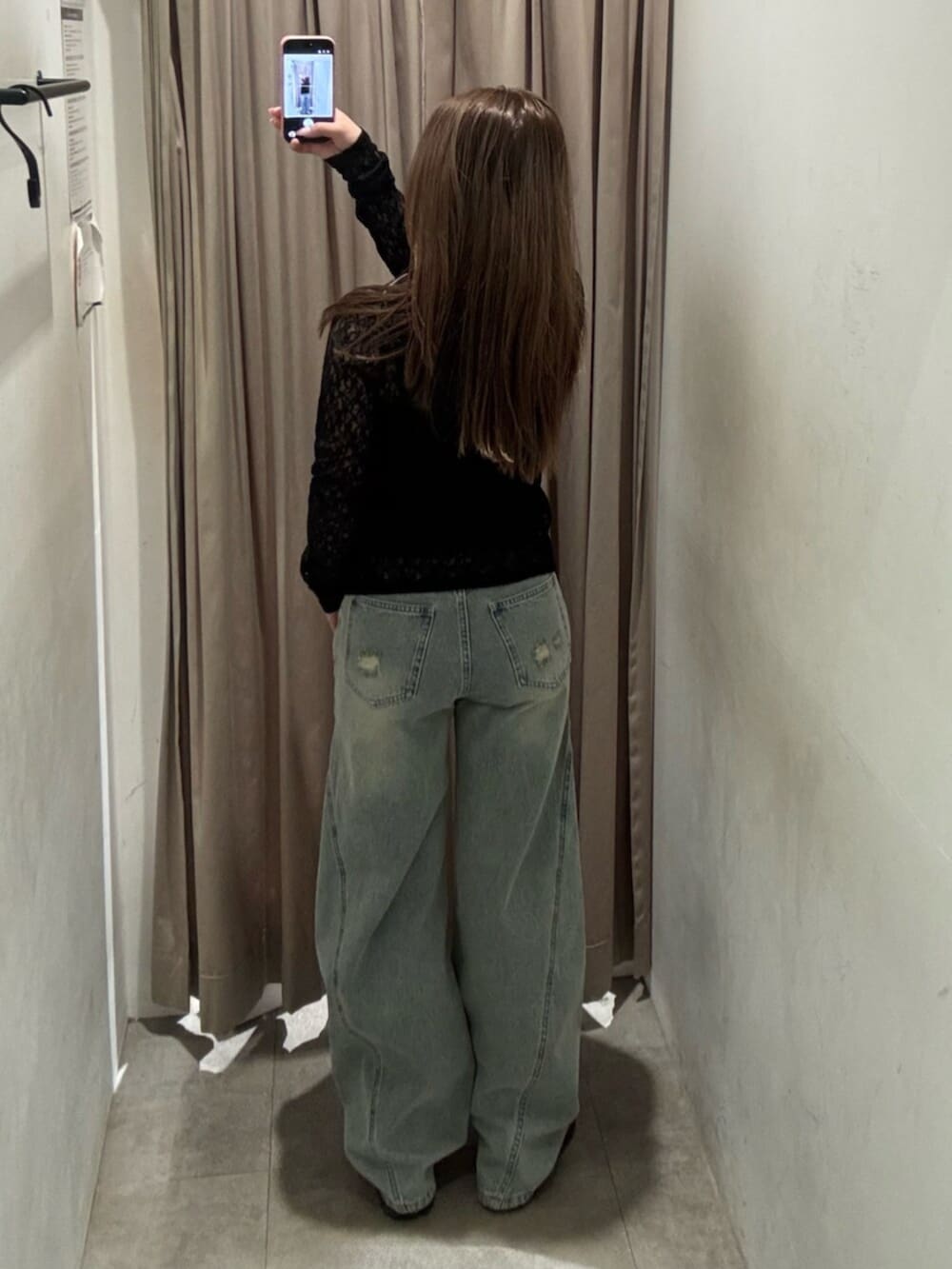 ブラック系のブーツ、ブルー系のデニムパンツ、ブラック系のパーカーを着用したレディースの春コーディネートの3枚目の写真