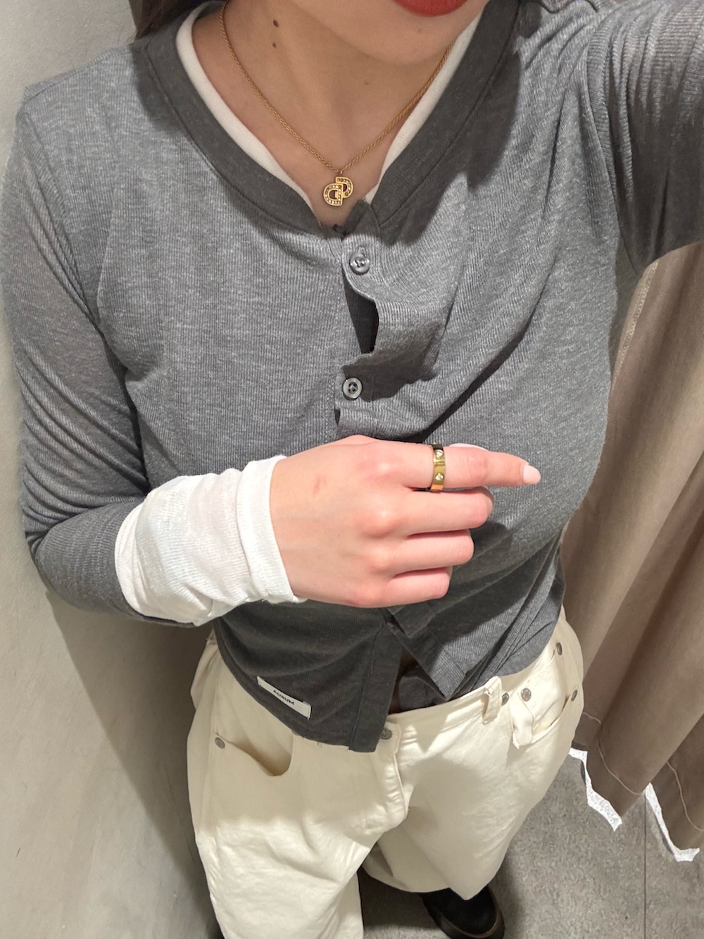 ホワイト系のデニムパンツ、グレー系のカーディガン/ボレロ、ブラック系のブーツを着用したレディースの春コーディネートの5枚目の写真