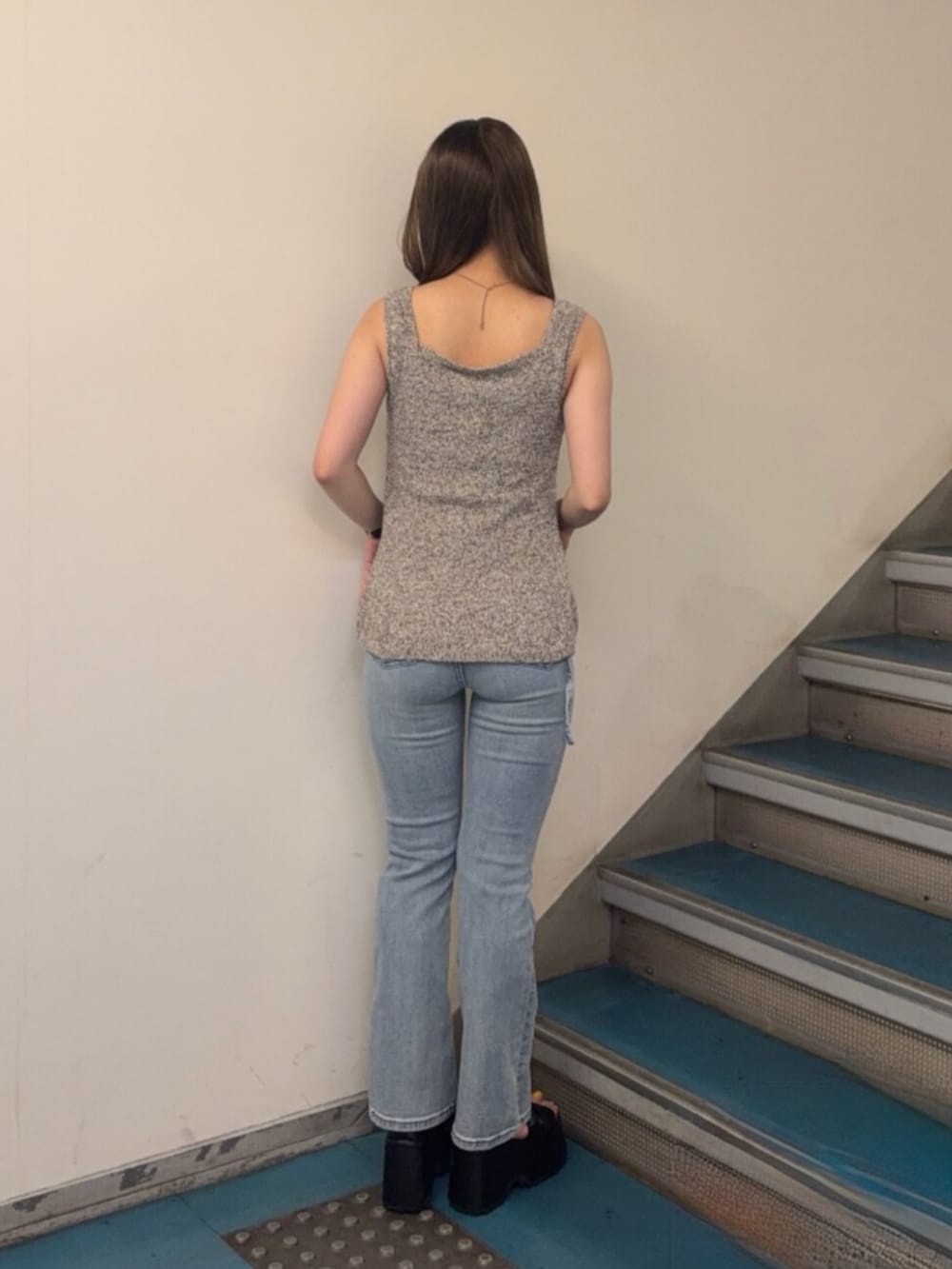 ブラック系のブーツ、ブルー系のデニムパンツ、ベージュ系のタンクトップを着用したレディースの夏コーディネートの3枚目の写真