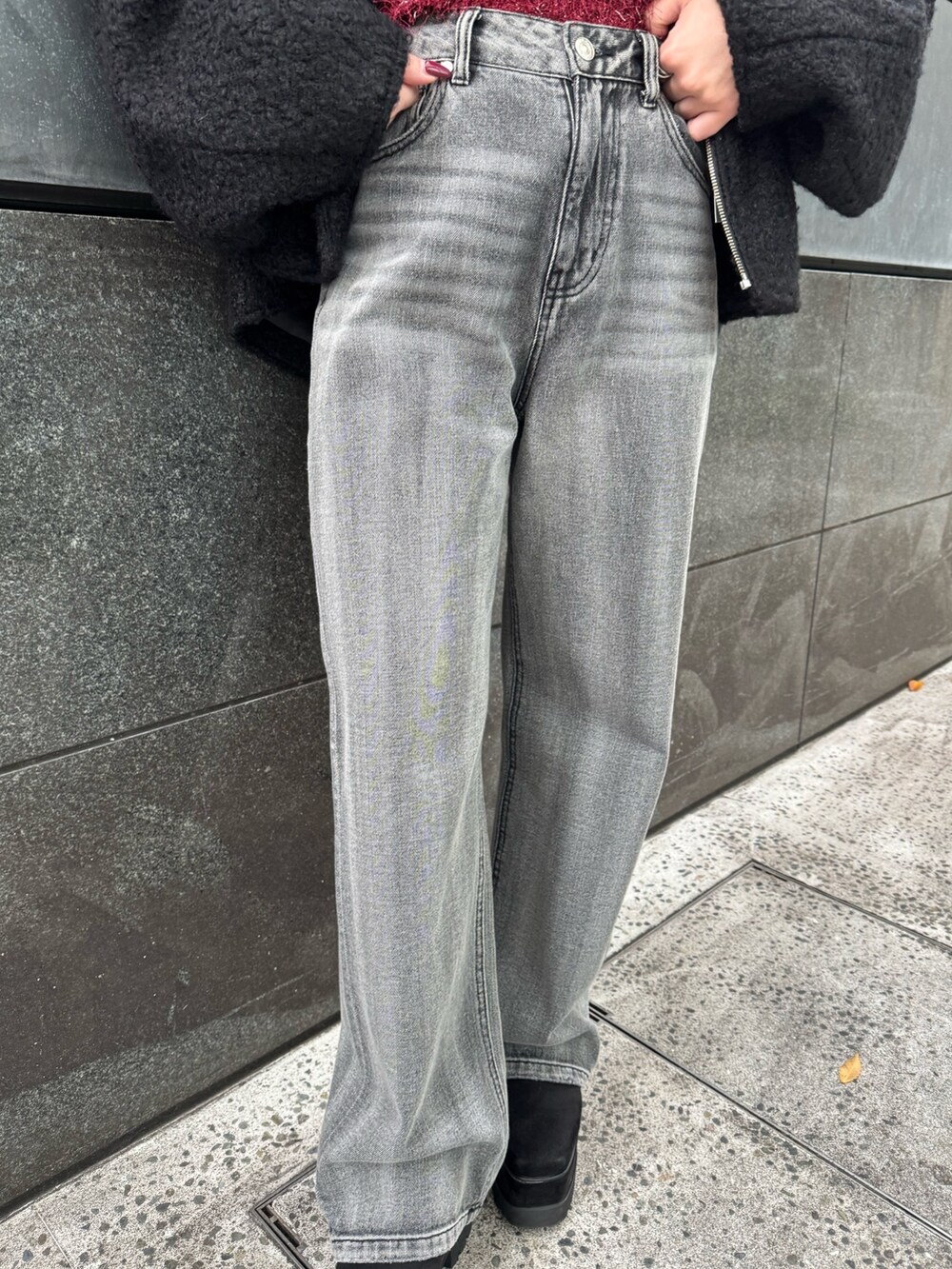 レッド系のニット/セーター、ブラック系のデニムパンツ、ブラック系のブーツを着用したレディースの冬コーディネートの6枚目の写真