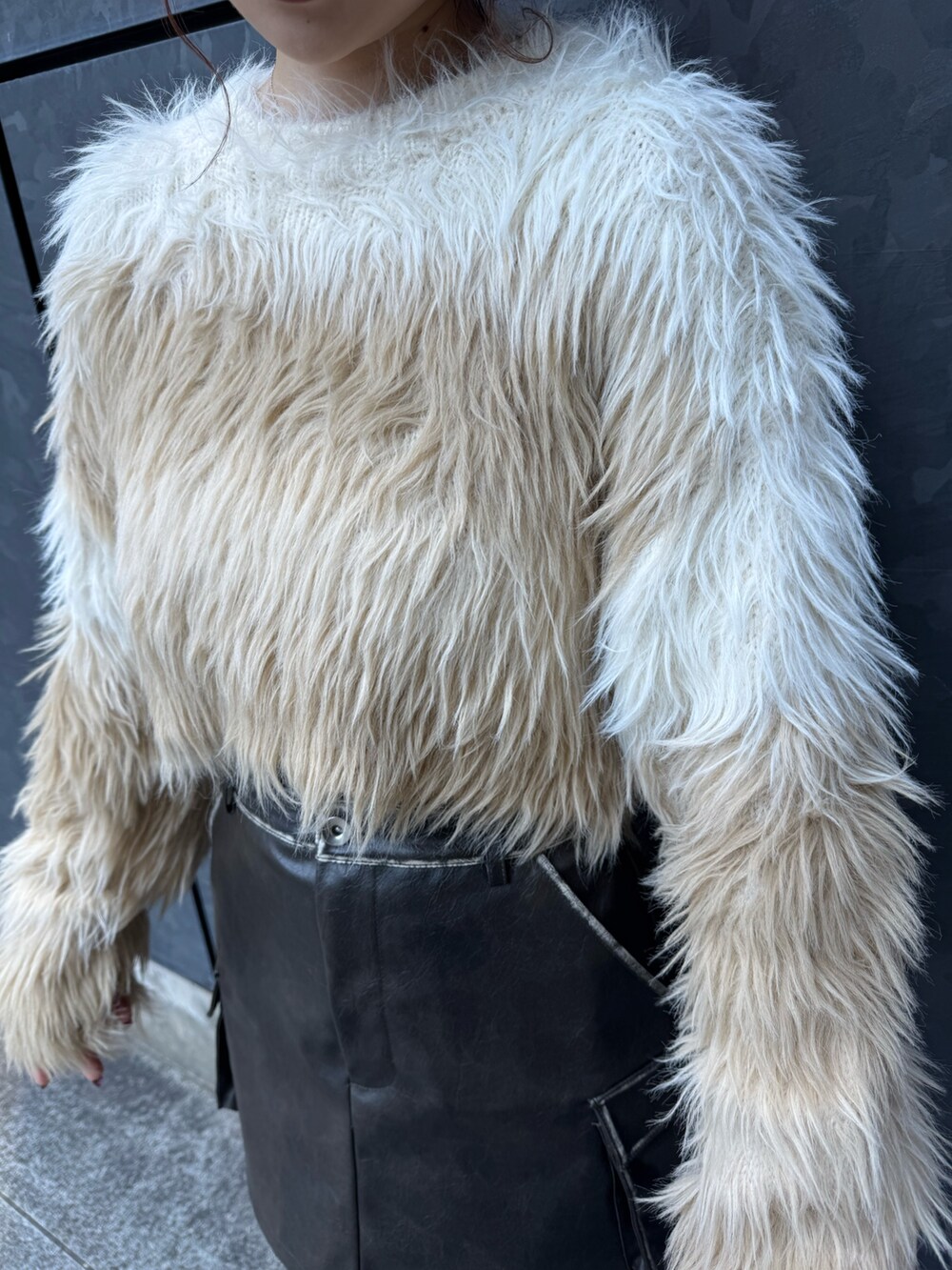 ホワイト系のニット/セーター、ブラウン系のスカート、ブラック系のブーツを着用したレディースの冬コーディネートの5枚目の写真