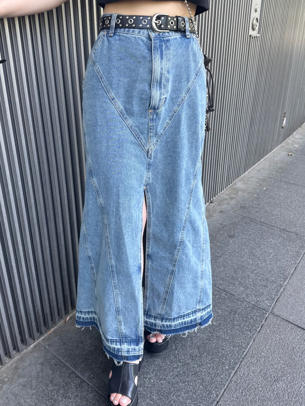 ブラック系のTシャツ/カットソー、ブルー系のデニムスカート、ブラック系のサンダルを着用したレディースの春コーディネートの7枚目の写真