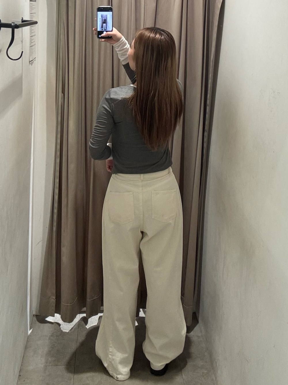 ホワイト系のデニムパンツ、グレー系のカーディガン/ボレロ、ブラック系のブーツを着用したレディースの春コーディネートの3枚目の写真