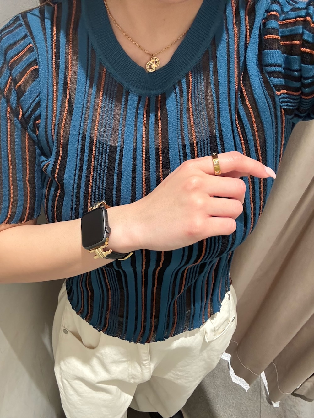 ホワイト系のデニムパンツ、ブルー系のニット/セーター、ブラック系のブーツを着用したレディースの春コーディネートの5枚目の写真