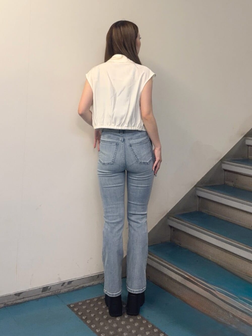 ブラック系のブーツ、ブルー系のデニムパンツ、ホワイト系のシャツ/ブラウスを着用したレディースの夏コーディネートの3枚目の写真