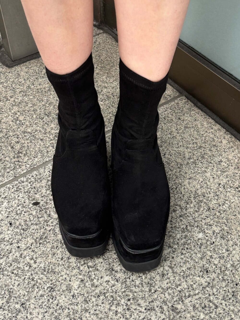 ブラック系のワンピース、ブラック系のブーツを着用したレディースの冬コーディネートの6枚目の写真