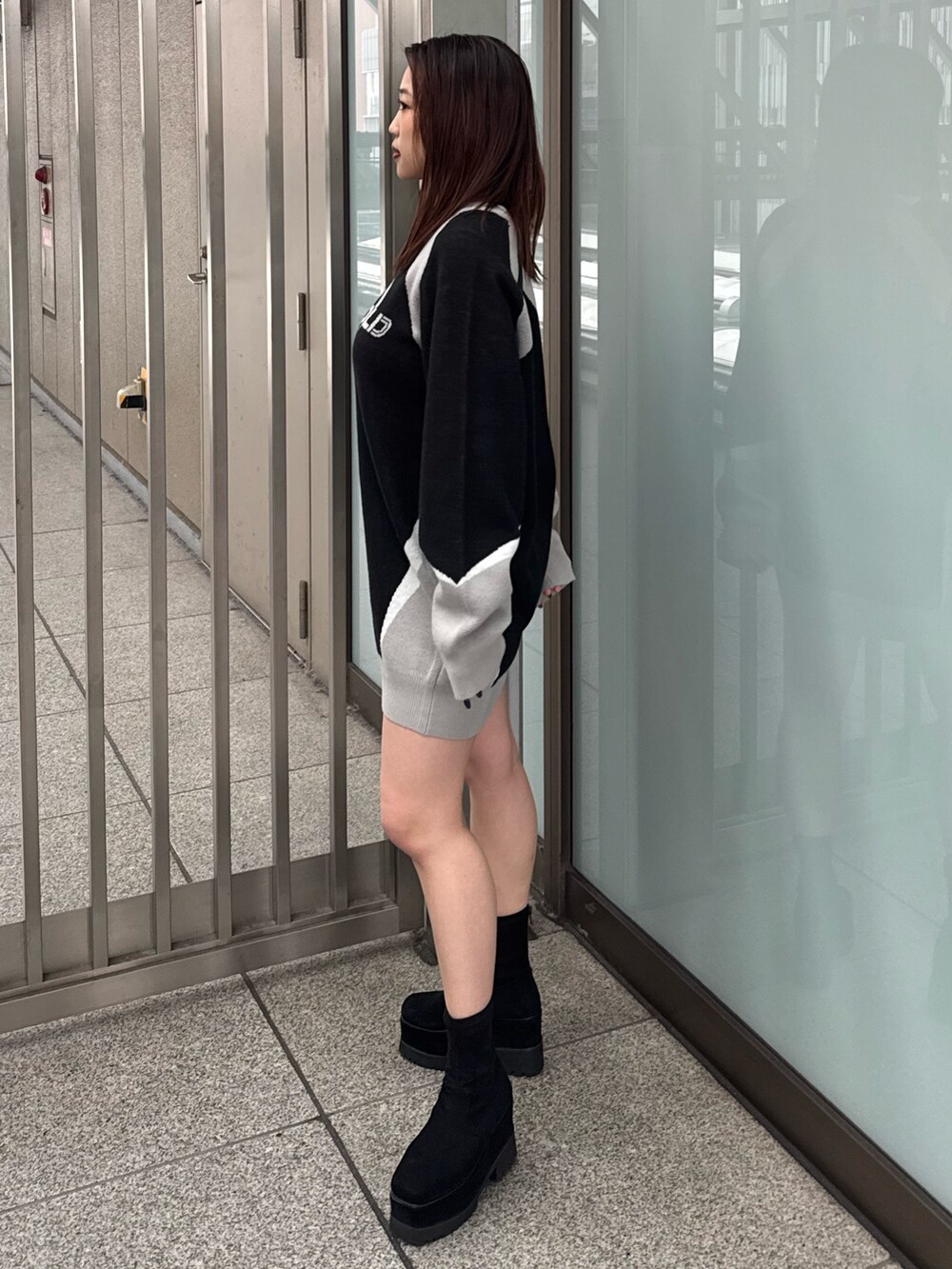 ブラック系のワンピース、ブラック系のブーツを着用したレディースの冬コーディネートの2枚目の写真