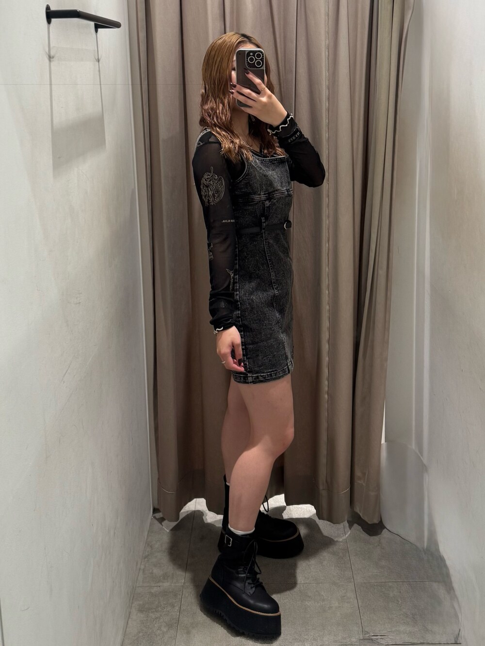 ブラック系のワンピース、ブラック系のTシャツ/カットソー、ブラック系のブーツを着用したレディースの秋コーディネートの2枚目の写真