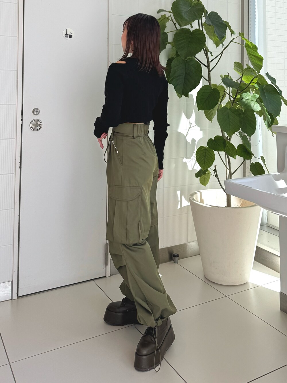 ブラック系のニット/セーター、ベージュ系のカーゴパンツ、ブラウン系のブーツを着用したレディースの秋コーディネートの2枚目の写真