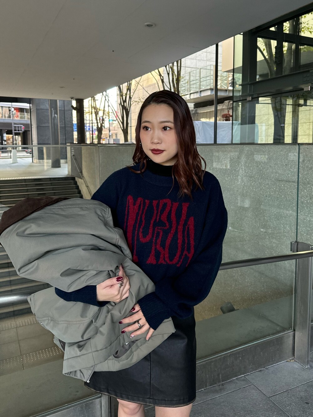 ブルー系のニット/セーター、ブラック系のスカート、ブラック系のブーツを着用したレディースの秋コーディネートの4枚目の写真