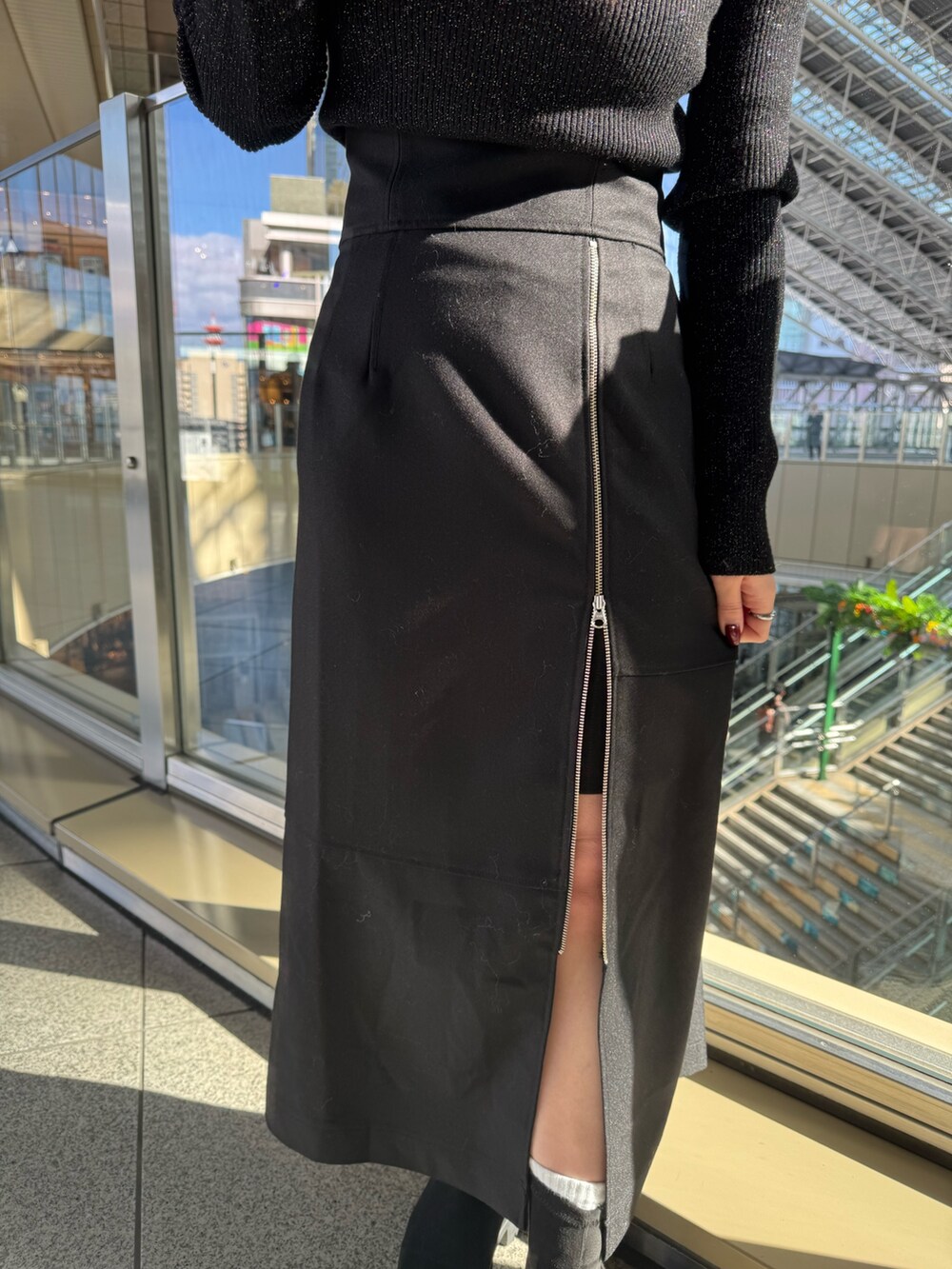 ブラウン系のブルゾン、ブラック系のスカート、ブラック系のブーツを着用したレディースの冬コーディネートの6枚目の写真