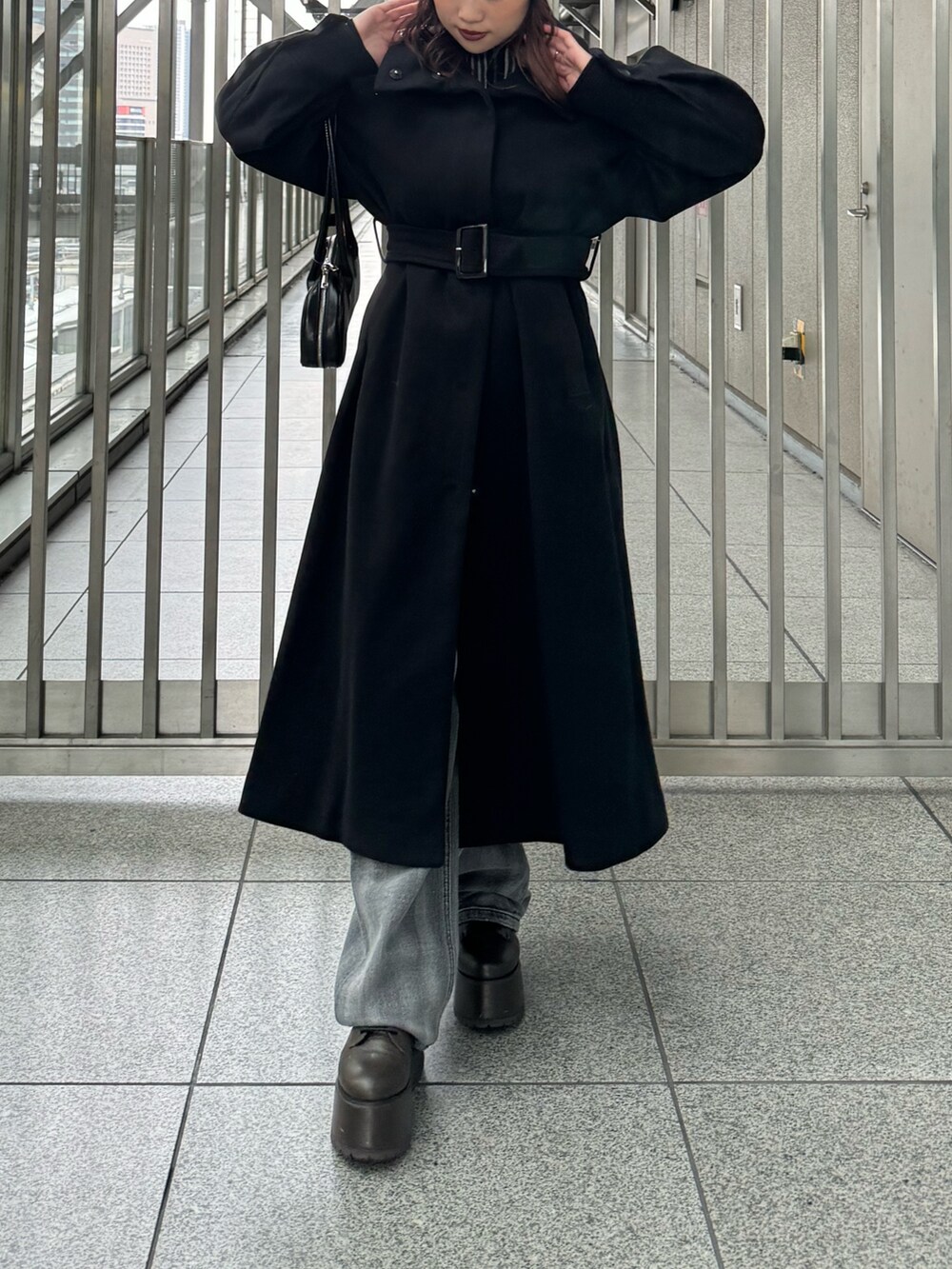 ブラック系のその他アウター、ブラック系のニット/セーター、ブラック系のデニムパンツを着用したレディースの秋コーディネートの4枚目の写真