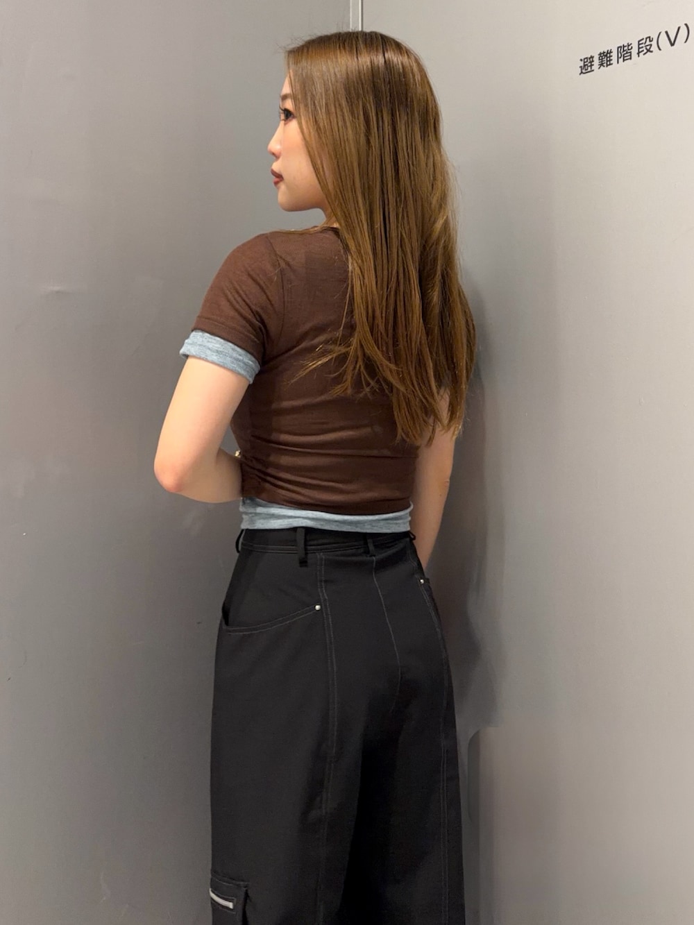 ブラック系のスラックス、ブラウン系のTシャツ/カットソー、ブラック系のブーツを着用したレディースの春コーディネートの4枚目の写真