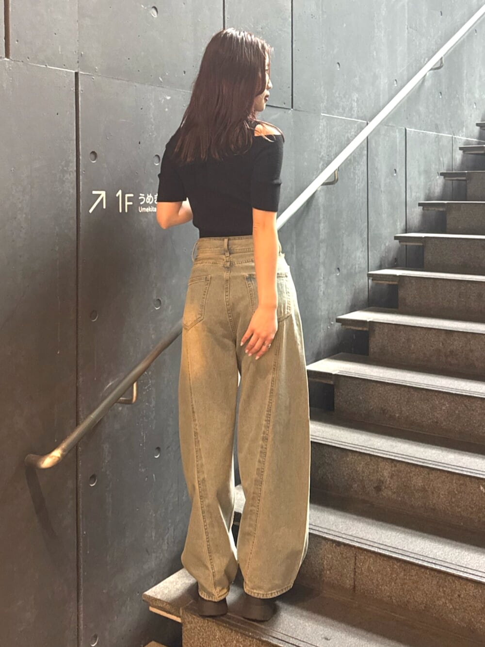 ブルー系のデニムパンツ、ブラック系のブーツ、ブラック系のニット/セーターを着用したレディースの春コーディネートの4枚目の写真