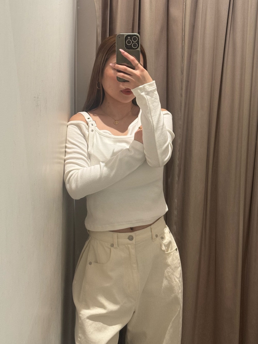 ホワイト系のデニムパンツ、ホワイト系のニット/セーター、ブラック系のブーツを着用したレディースの春コーディネートの4枚目の写真