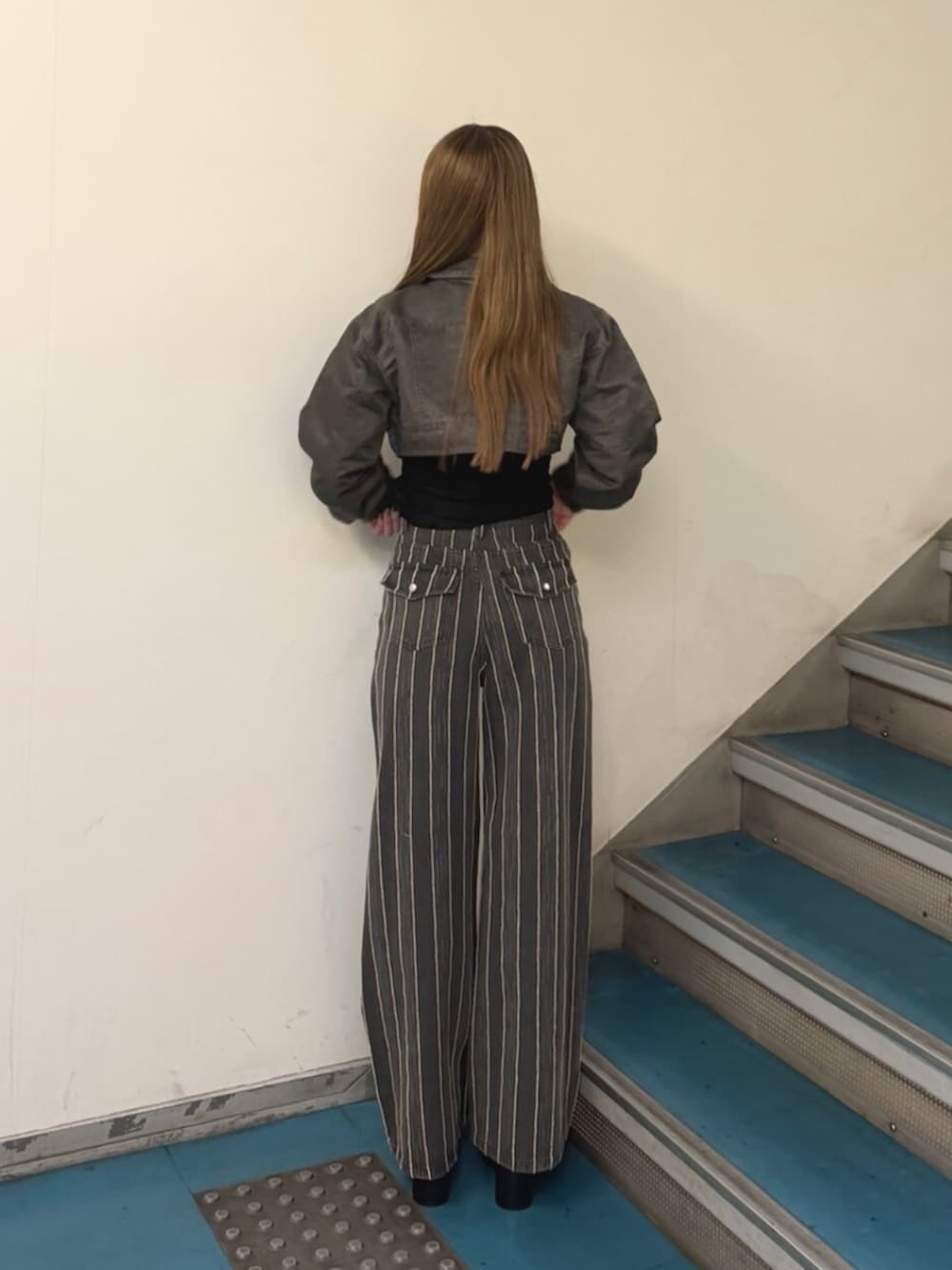 ブラック系のTシャツ/カットソー、ブラック系のデニムパンツ、ブラック系のブーツを着用したレディースの秋コーディネートの3枚目の写真