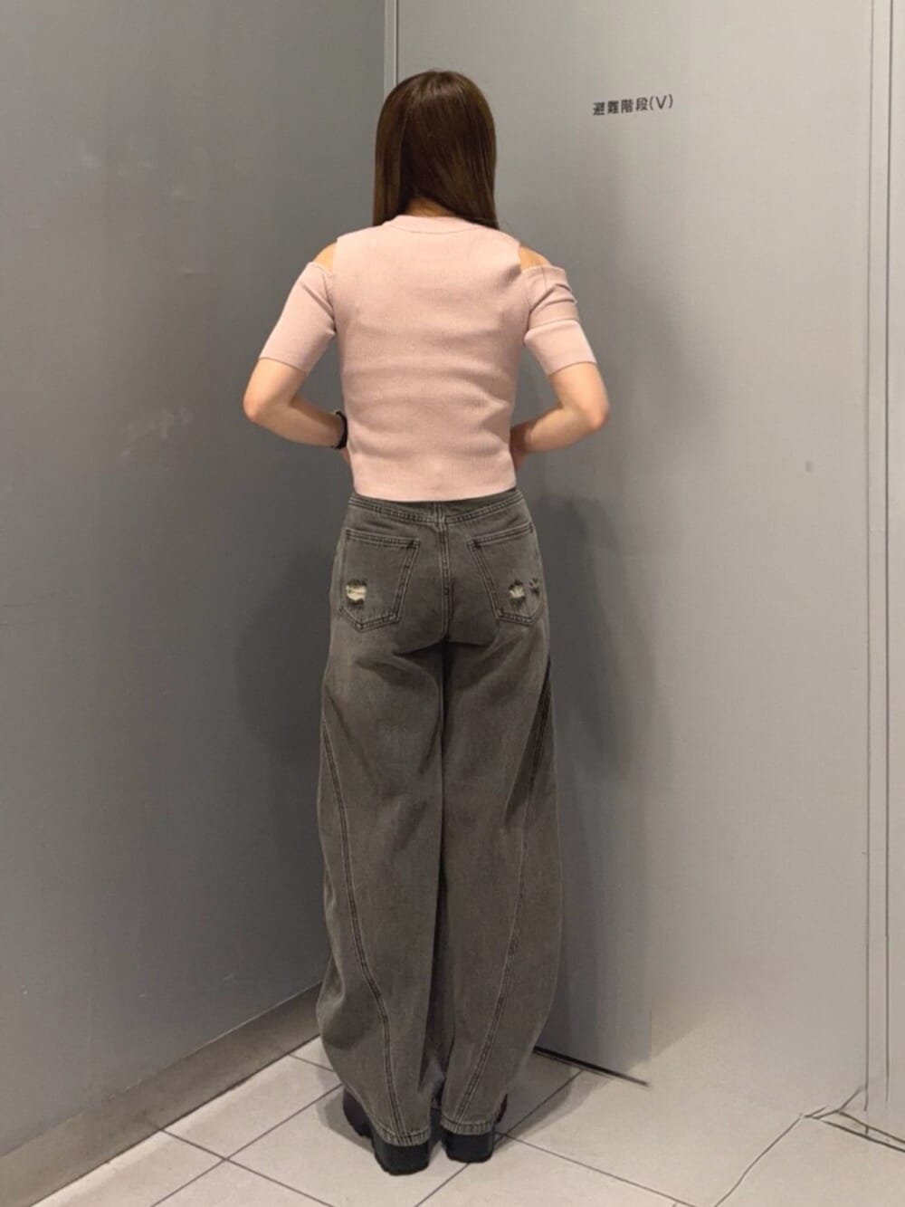 グレー系のデニムパンツ、ブラック系のブーツ、ピンク系のニット/セーターを着用したレディースの春コーディネートの3枚目の写真