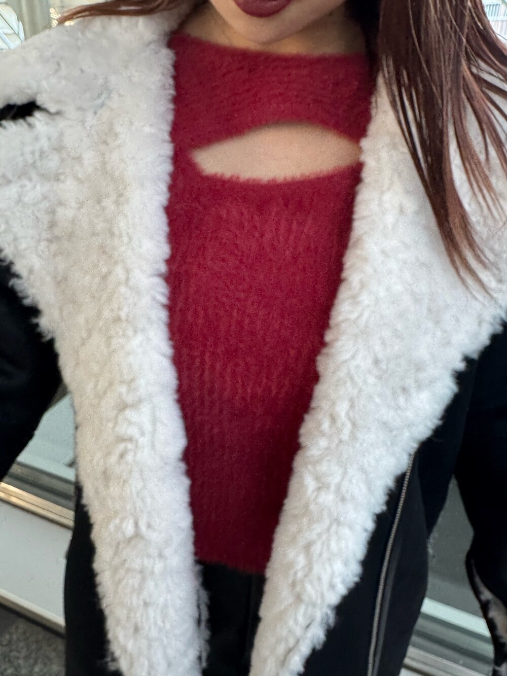 レッド系のニット/セーター、ブラウン系のスカート、ブラック系のムートンコートを着用したレディースの冬コーディネートの5枚目の写真