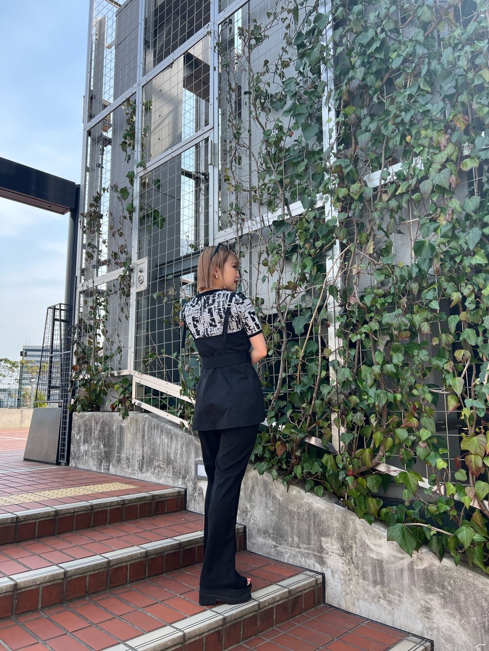 ブラック系のニット/セーター、ブラック系のシャツ/ブラウス、ブラック系のその他パンツを着用したレディースの春コーディネートの7枚目の写真