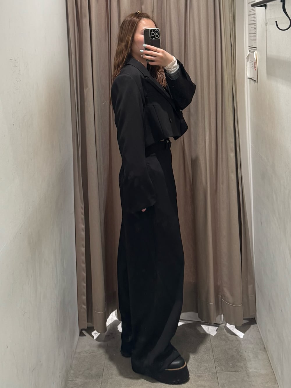 ブラック系のスラックス、ブラック系のテーラードジャケット、グレー系のTシャツ/カットソーを着用したレディースの冬コーディネートの2枚目の写真